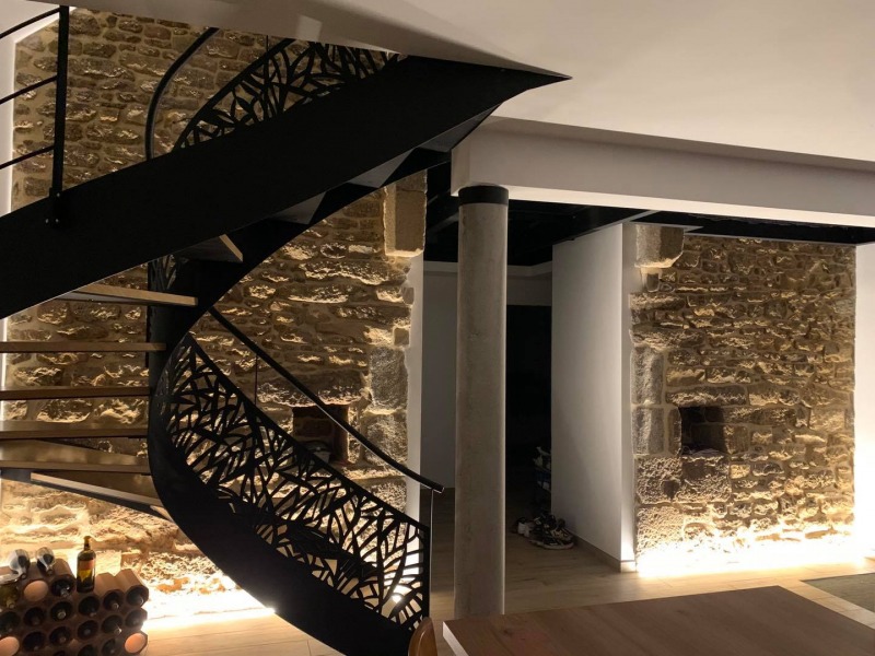 Vue globale de l’installation avec les bandes LED, l’escalier et le mur en pierre d’origine.