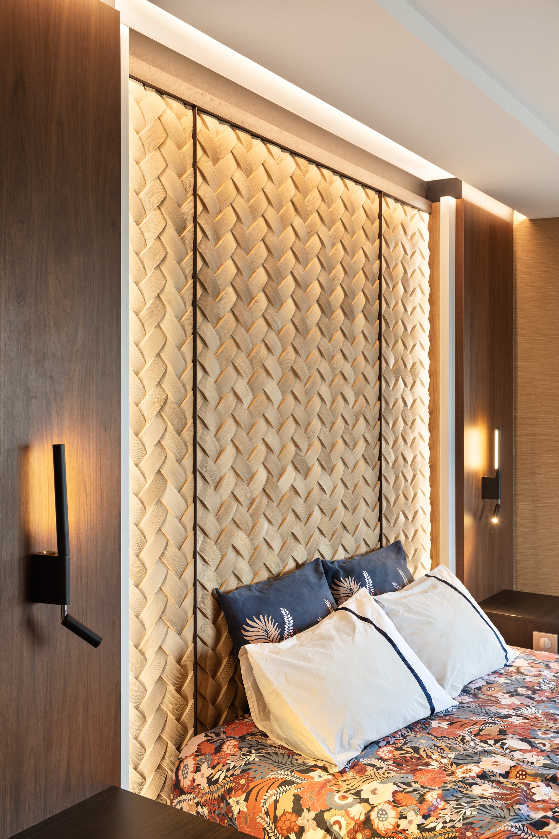 Chambre principale : éclairages allumés avec bande LED sur mur texturé et appliques murales.